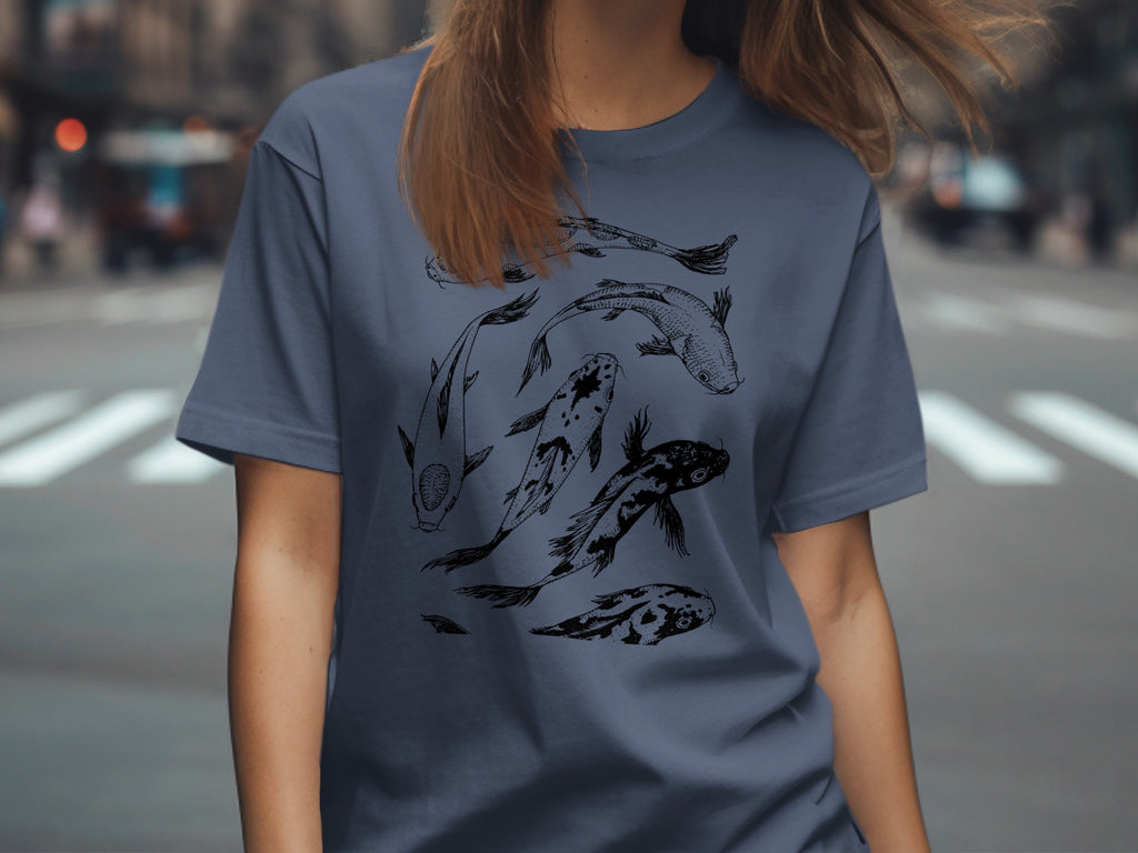 T-shirt with sketched black koi fish design on a dusty blue background.