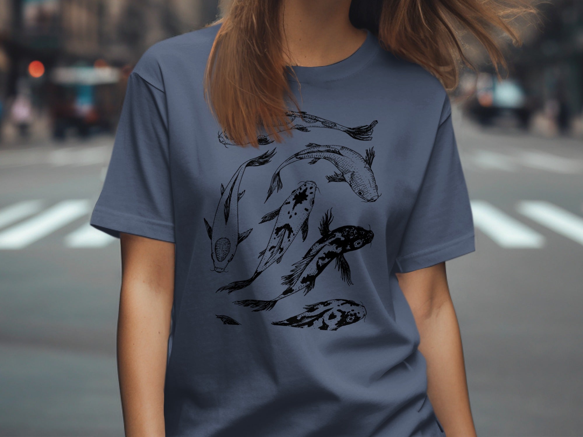 T-shirt with sketched black koi fish design on a dusty blue background.