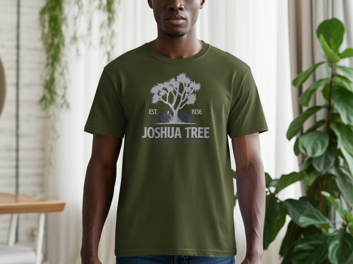 Green t-shirt with Joshua Tree National Park graphic featuring a tree, mountains, and text.