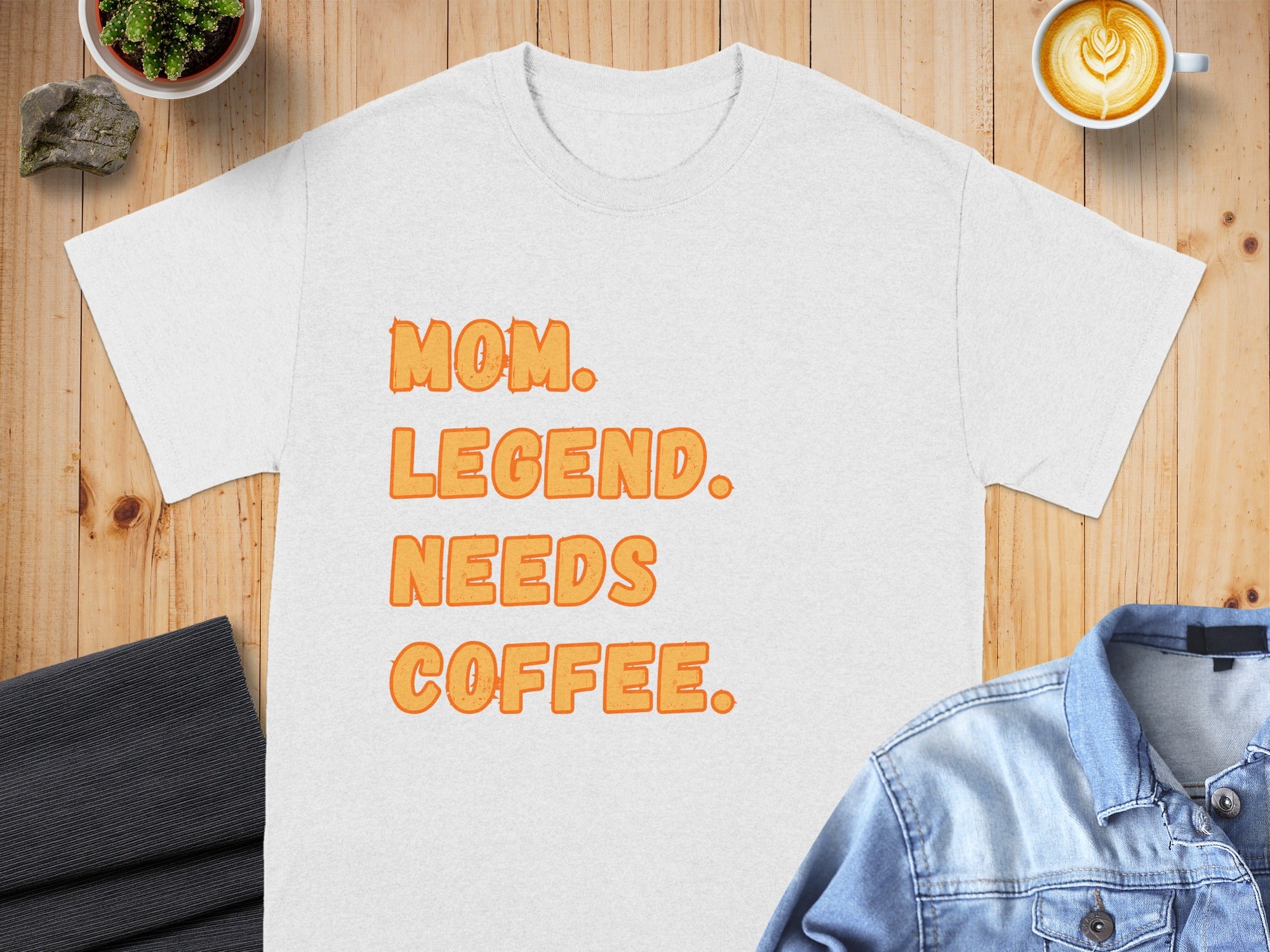 White t-shirt with orange text "MOM. LEGEND. NEEDS COFFEE."
