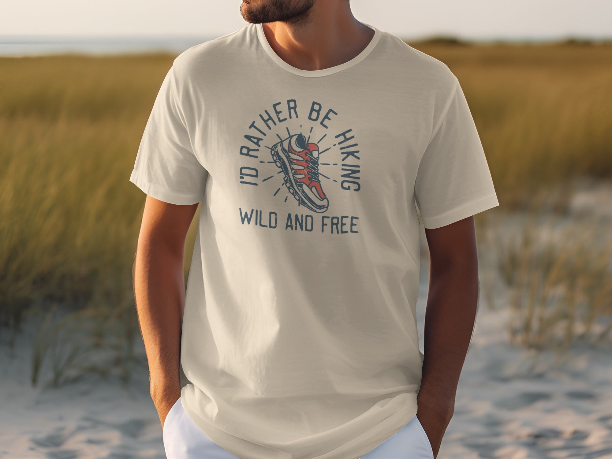 Cream t-shirt with graphic design of hiking boot and text "I'd Rather Be Hiking Wild and Free".