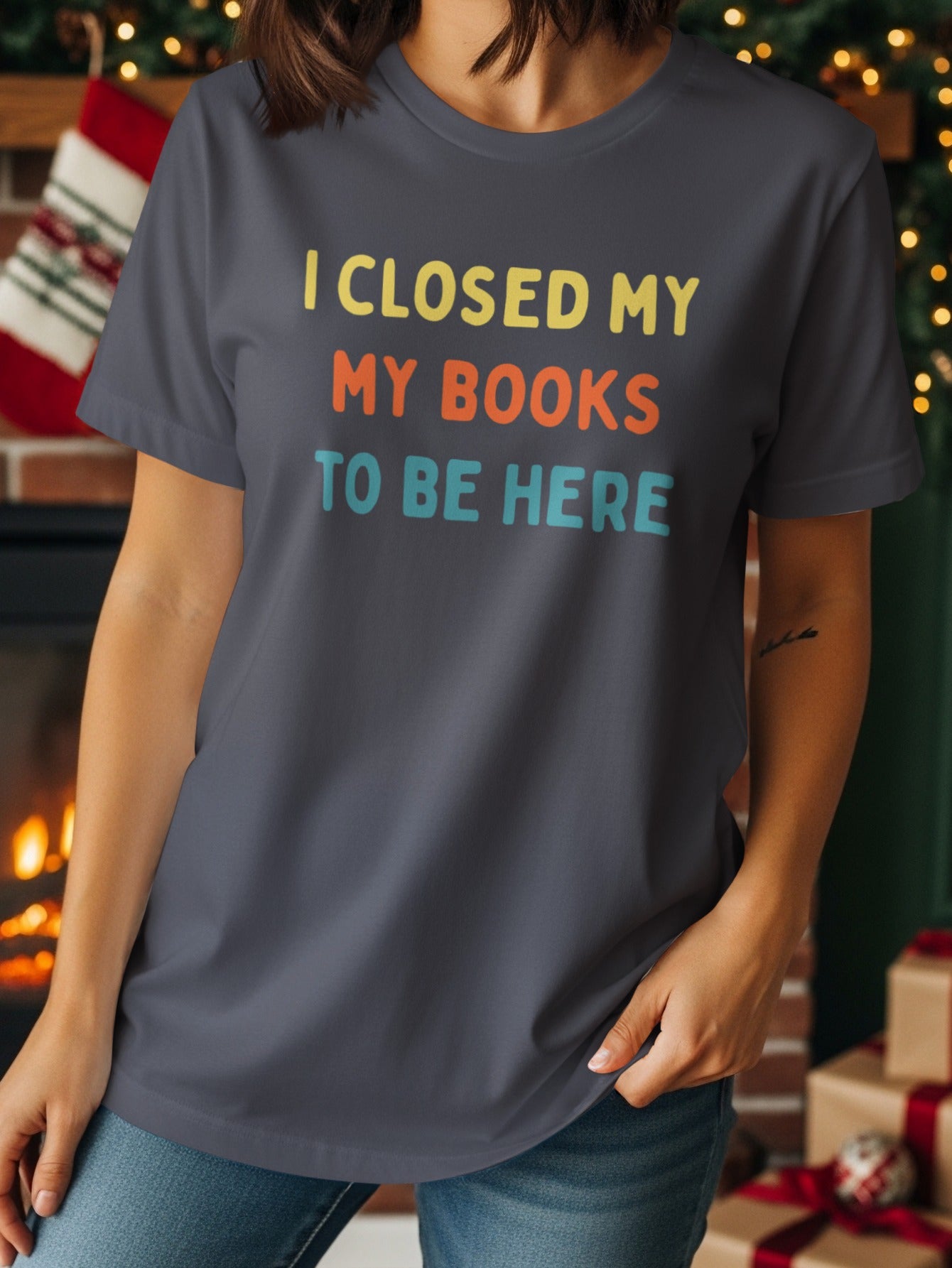 T-shirt with text "I CLOSED MY MY BOOKS TO BE HERE" in retro font.