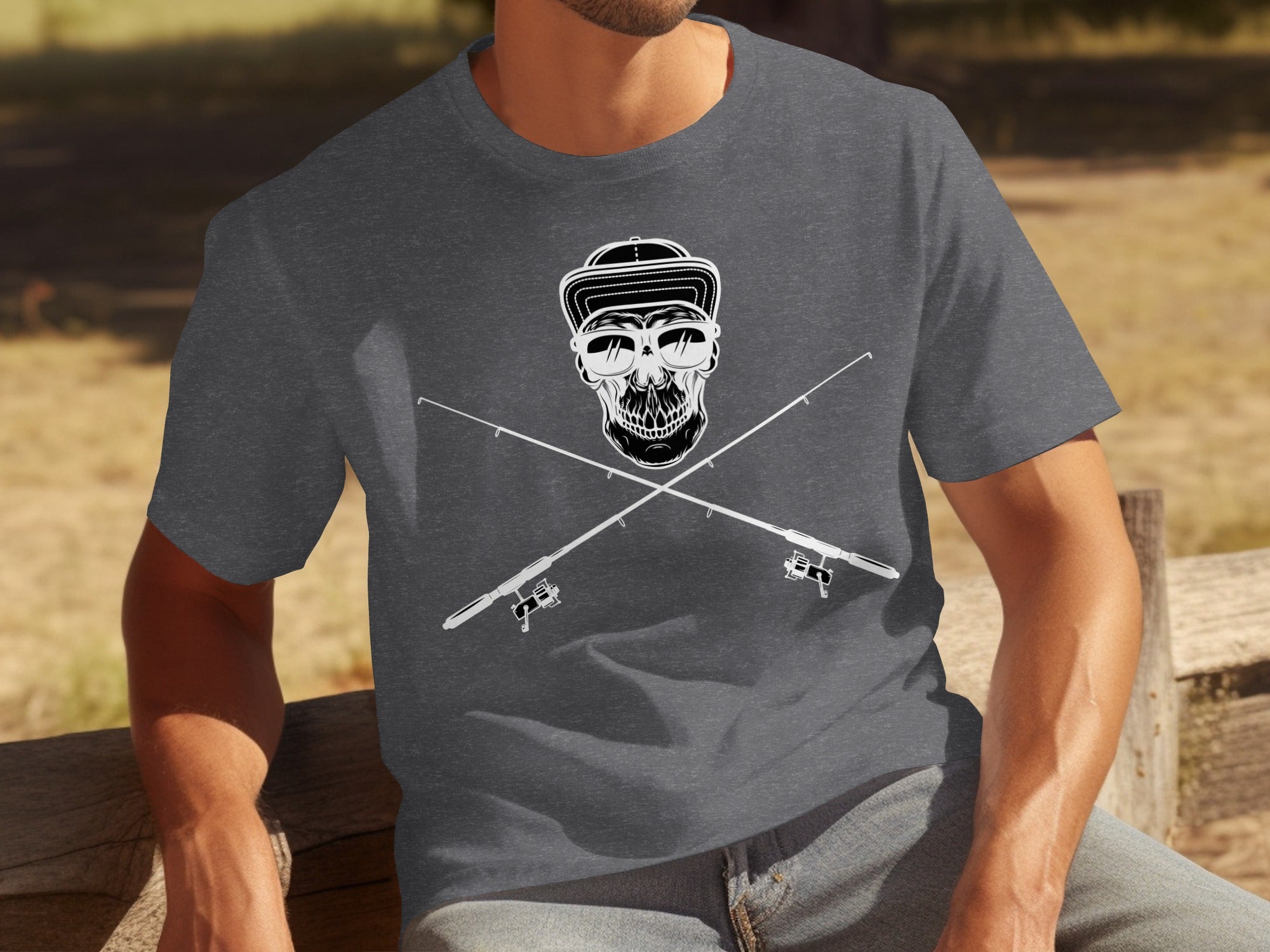 Skull with sunglasses and cap, crossed over fishing rods graphic on a charcoal t-shirt.