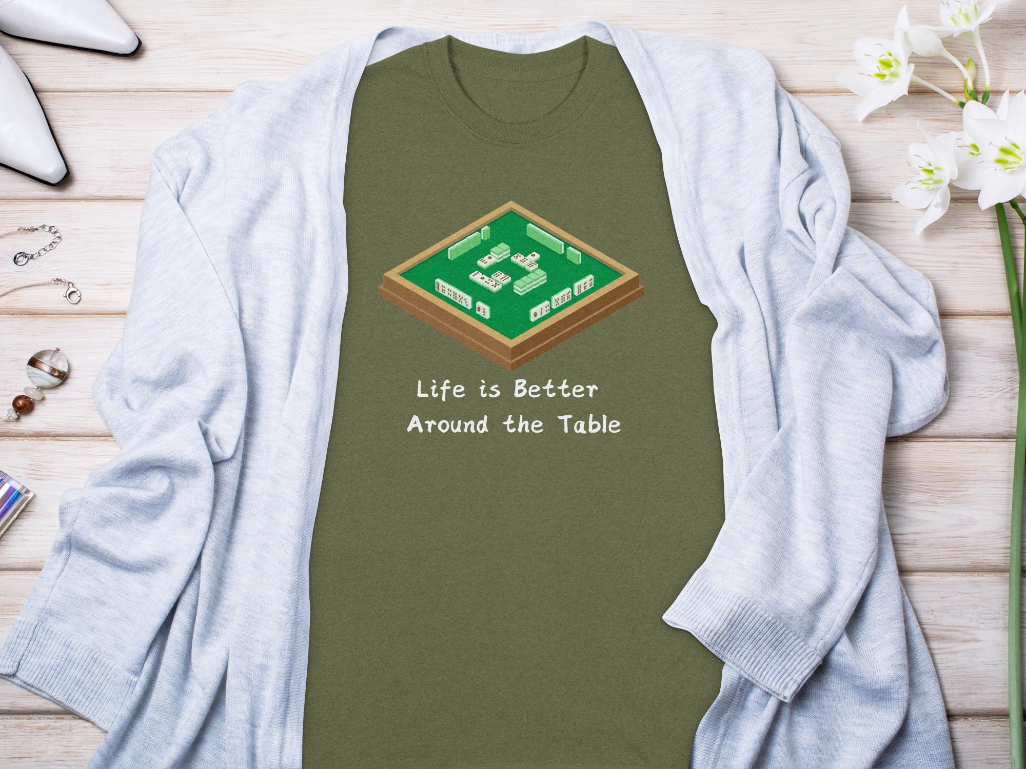 Olive green t-shirt with mahjong game graphic and text "Life is Better Around the Table."