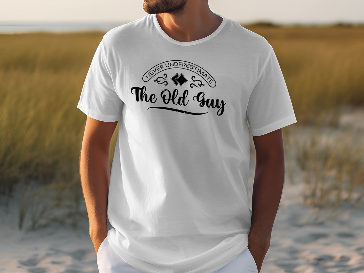White t-shirt with text "Never Underestimate The Old Guy" on the front.