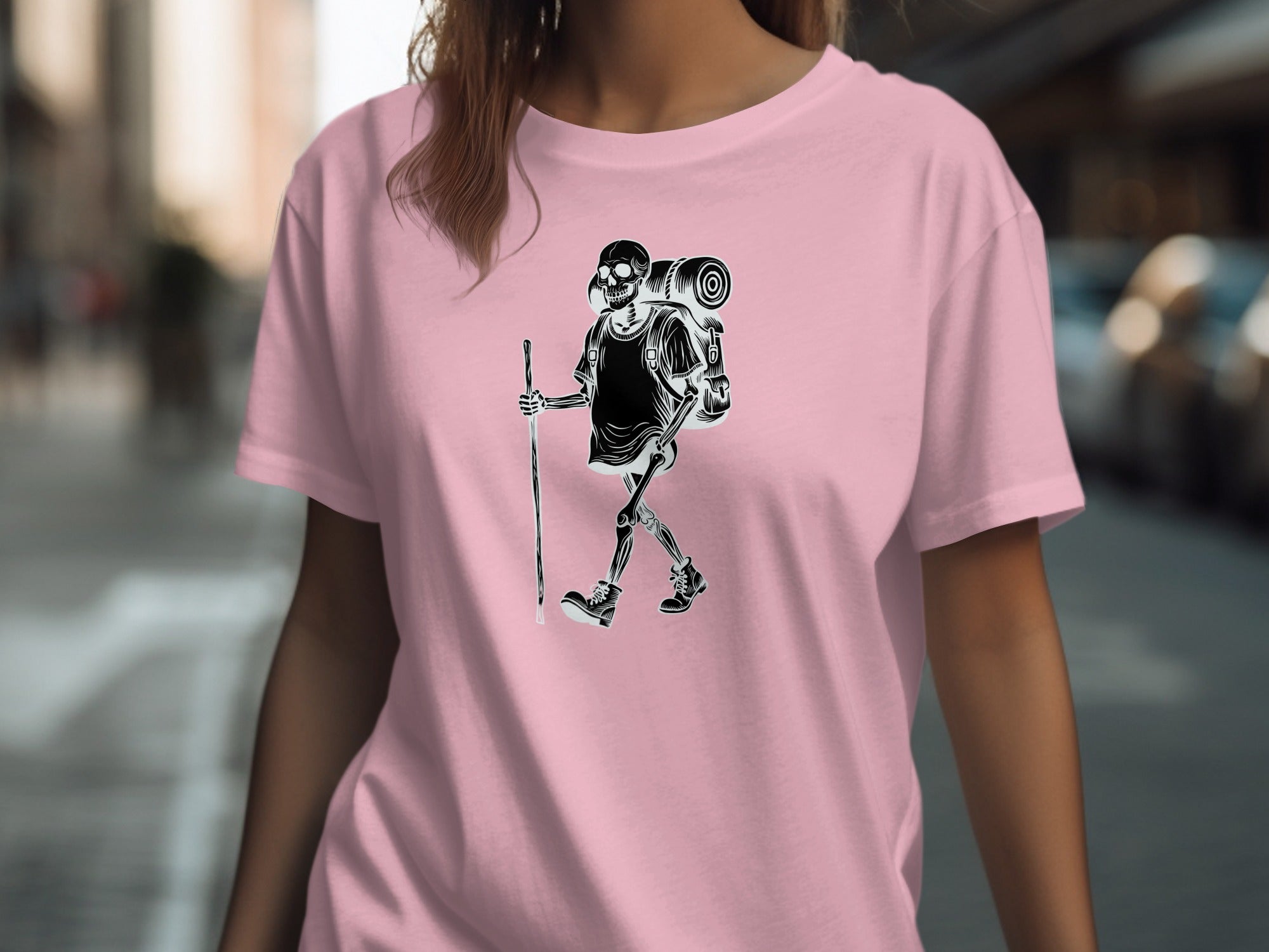 Black and white graphic of a skeleton hiker with backpack on a pink t-shirt.