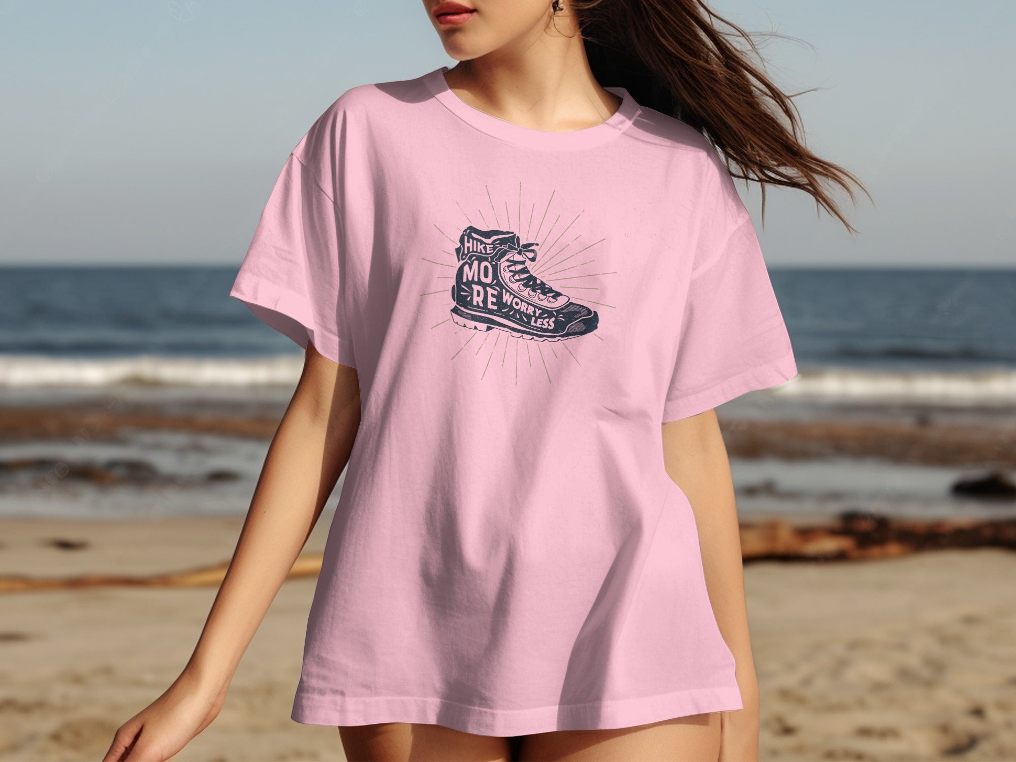 Pink t-shirt with graphic of hiking boot and text "Hike More Worry Less".