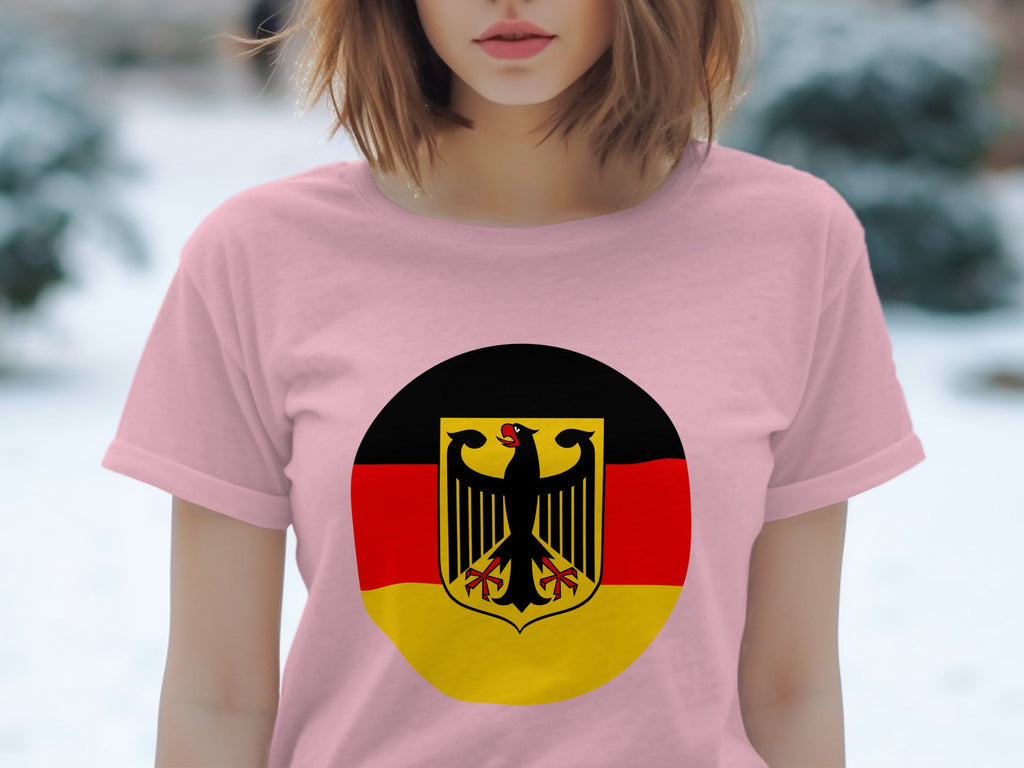 Pink t-shirt with a circular German flag emblem featuring a black eagle on a shield.