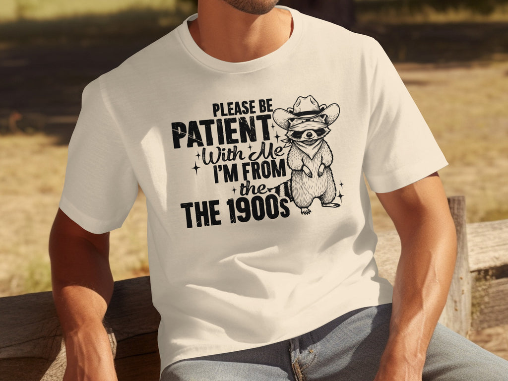 T-shirt with raccoon graphic and text "Please be patient with me, I'm from the 1900s".