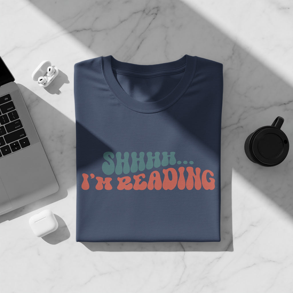 Dark blue t-shirt with "SHHHH... I'm READING" text in teal and coral.