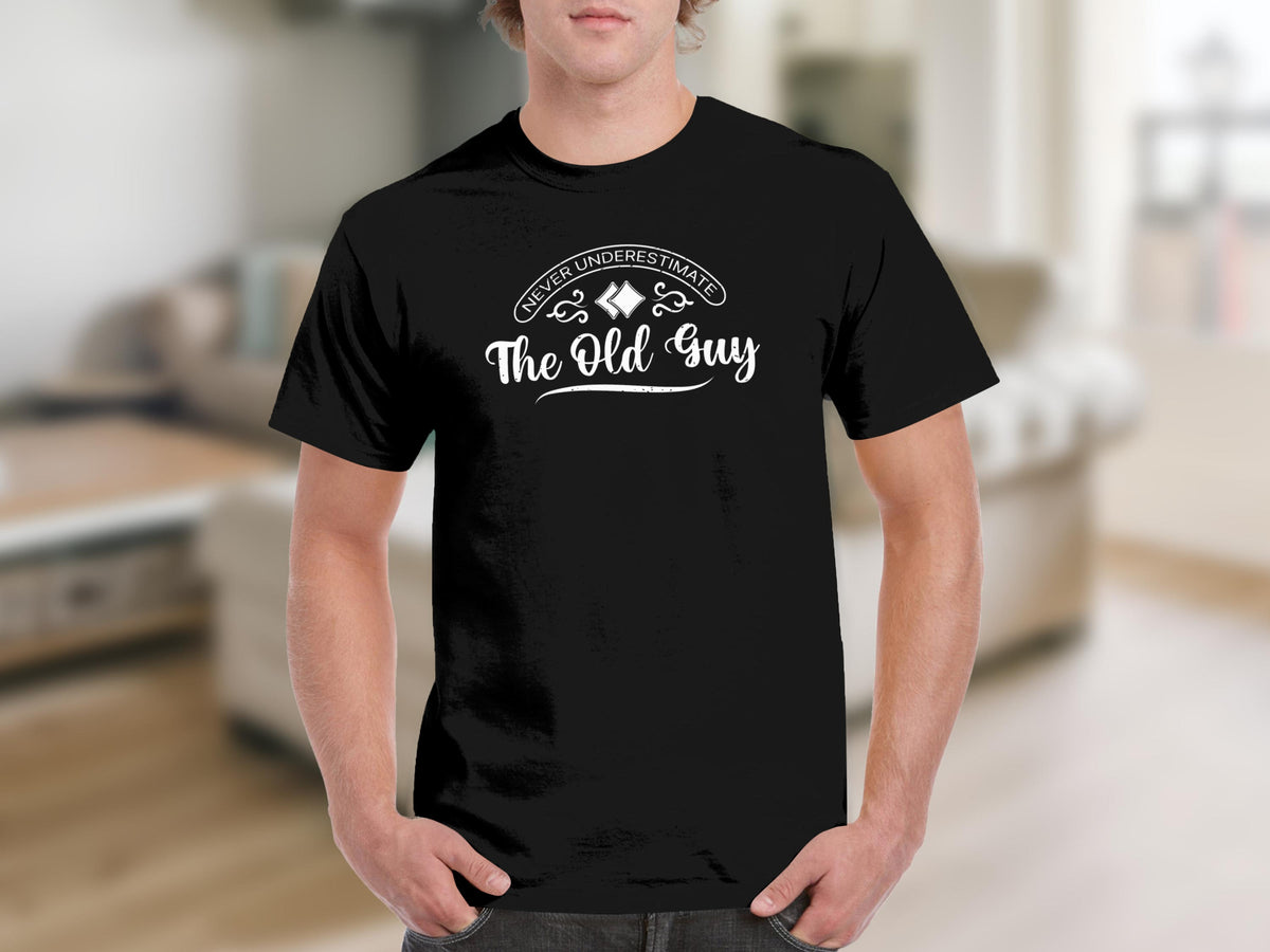 Black t-shirt with white text "Never Underestimate The Old Guy."