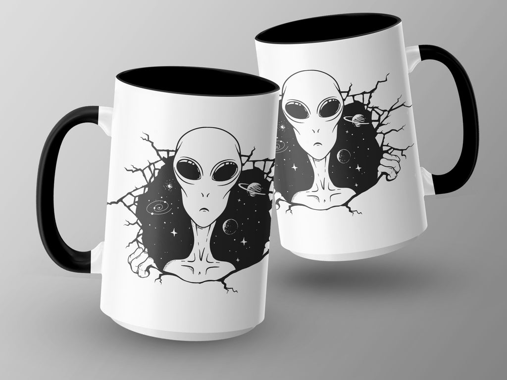 Two white mugs with black handles feature alien art and a starry space background.