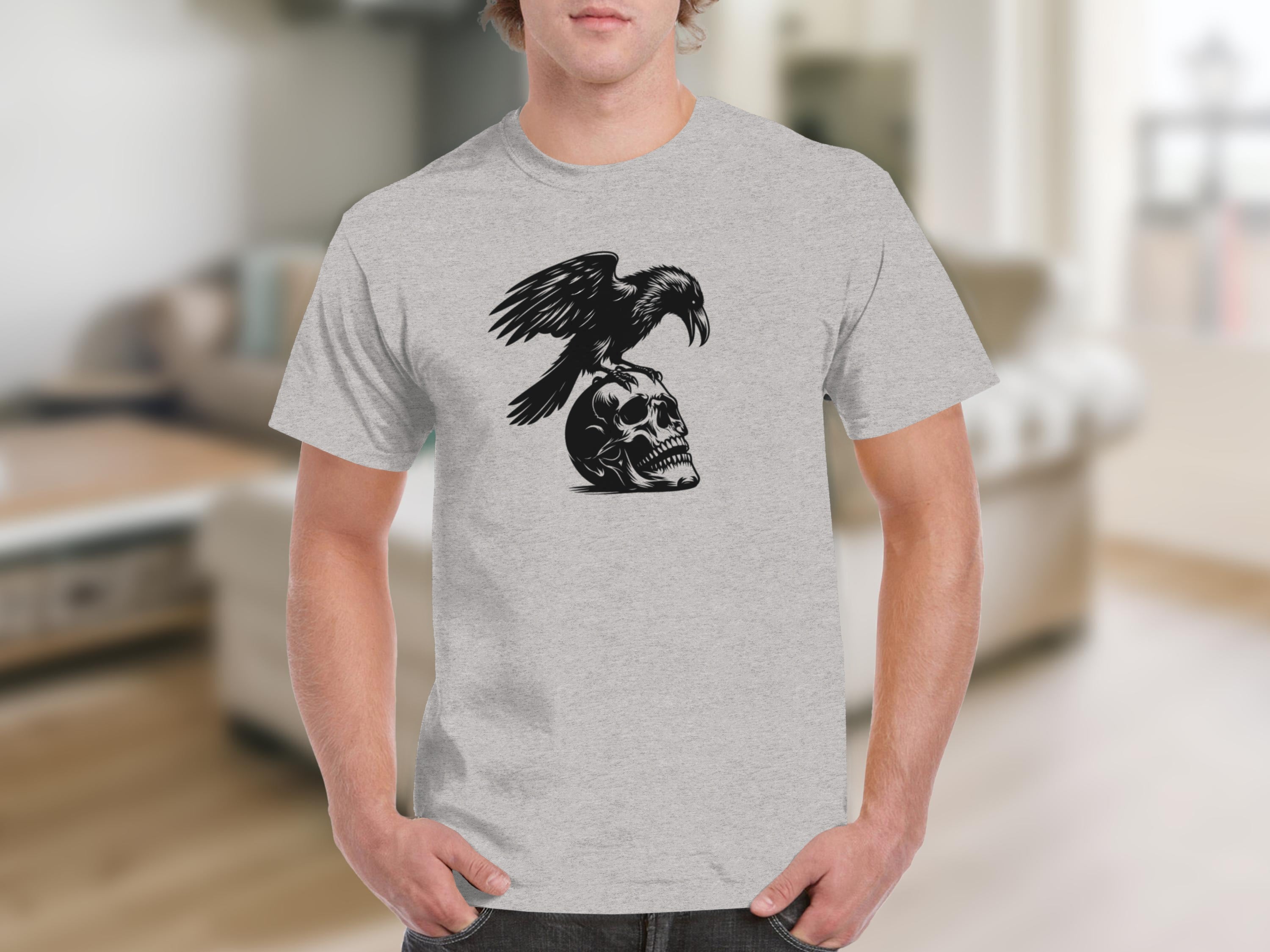Black raven perched on a skull graphic on a grey t-shirt.