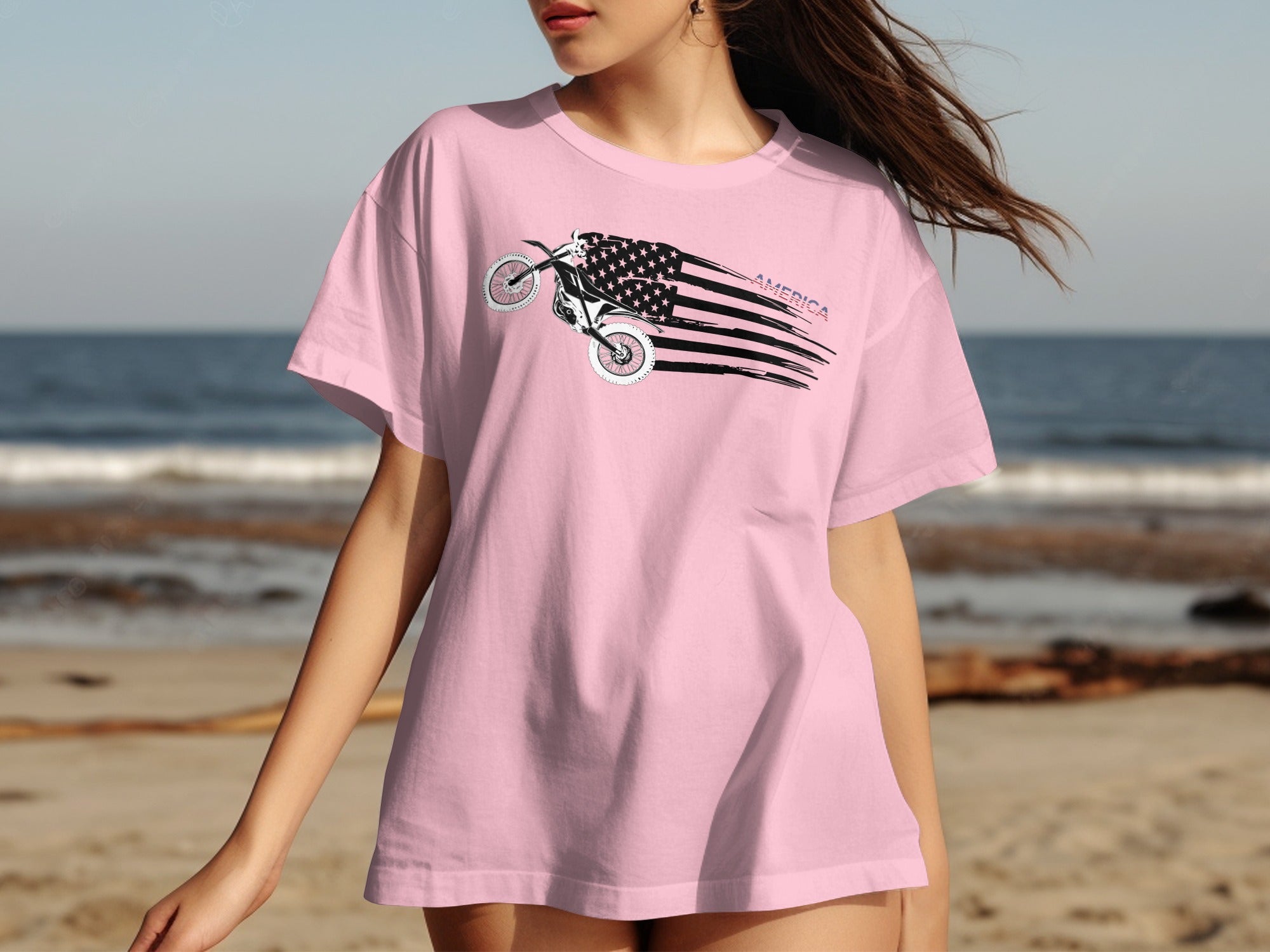 Pink t-shirt with a dirt bike graphic that incorporates the American flag and the word "America."