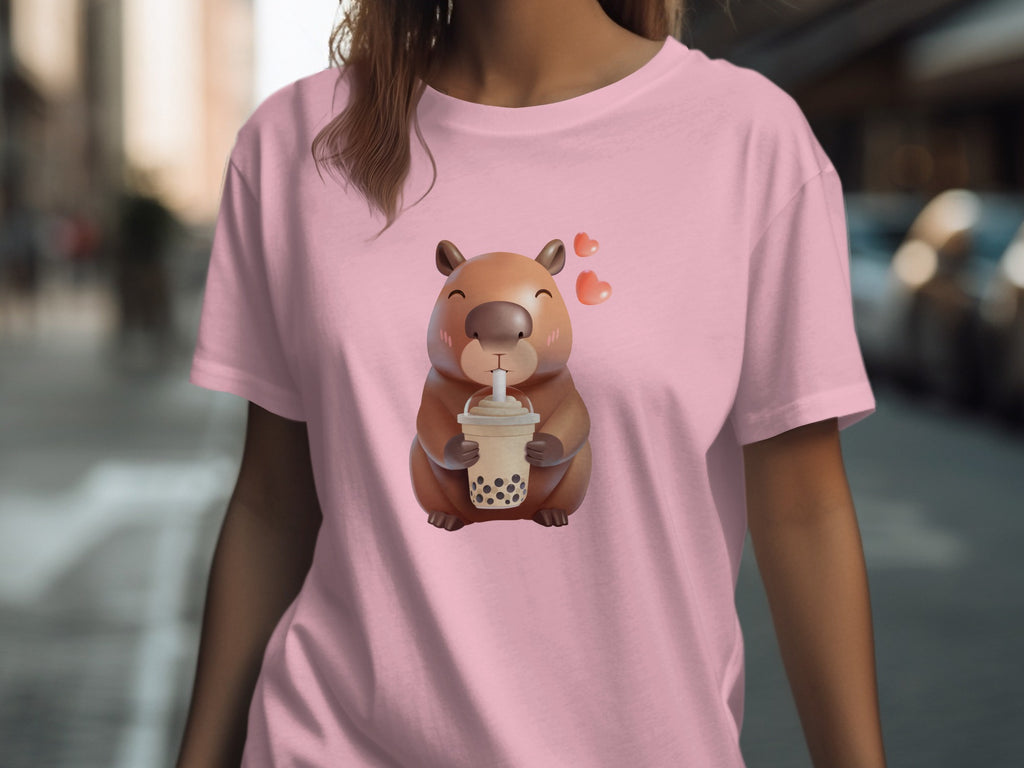 Cute capybara with hearts holding a bubble tea on a pink t-shirt.