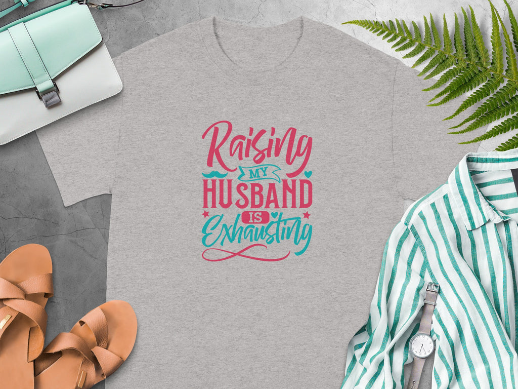 Grey t-shirt with text "Raising My Husband Is Exhausting" in pink and blue.