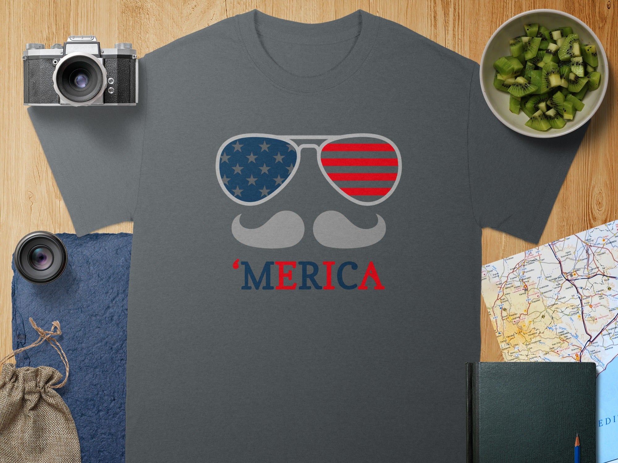 Dark gray t-shirt with "MERIC`A" and American flag sunglasses graphic.
