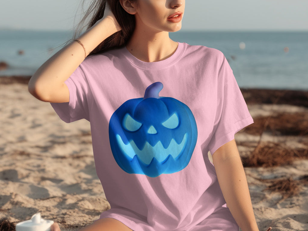 Pink t-shirt with blue Halloween jack-o'-lantern graphic on beach background