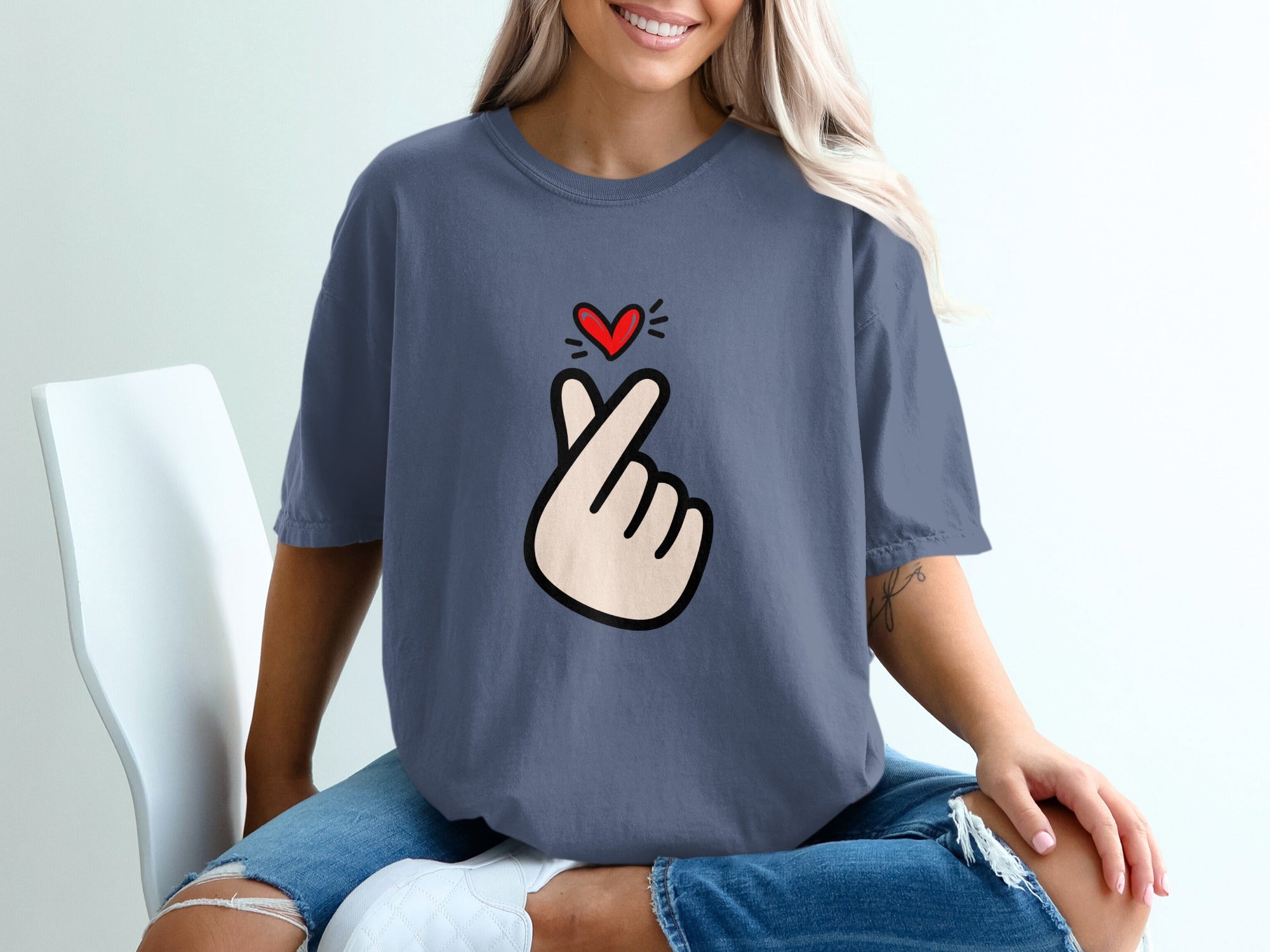 Blue t-shirt with a red heart gesture print on the chest.
