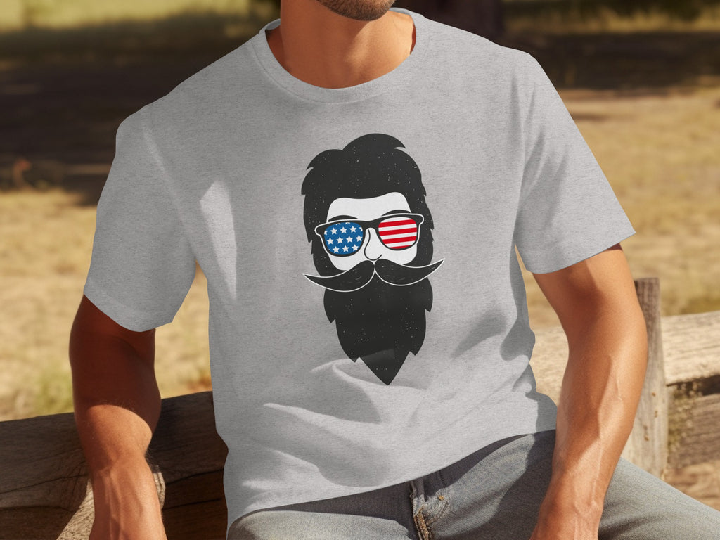 Grey t-shirt with a graphic of a bearded man wearing American flag sunglasses.
