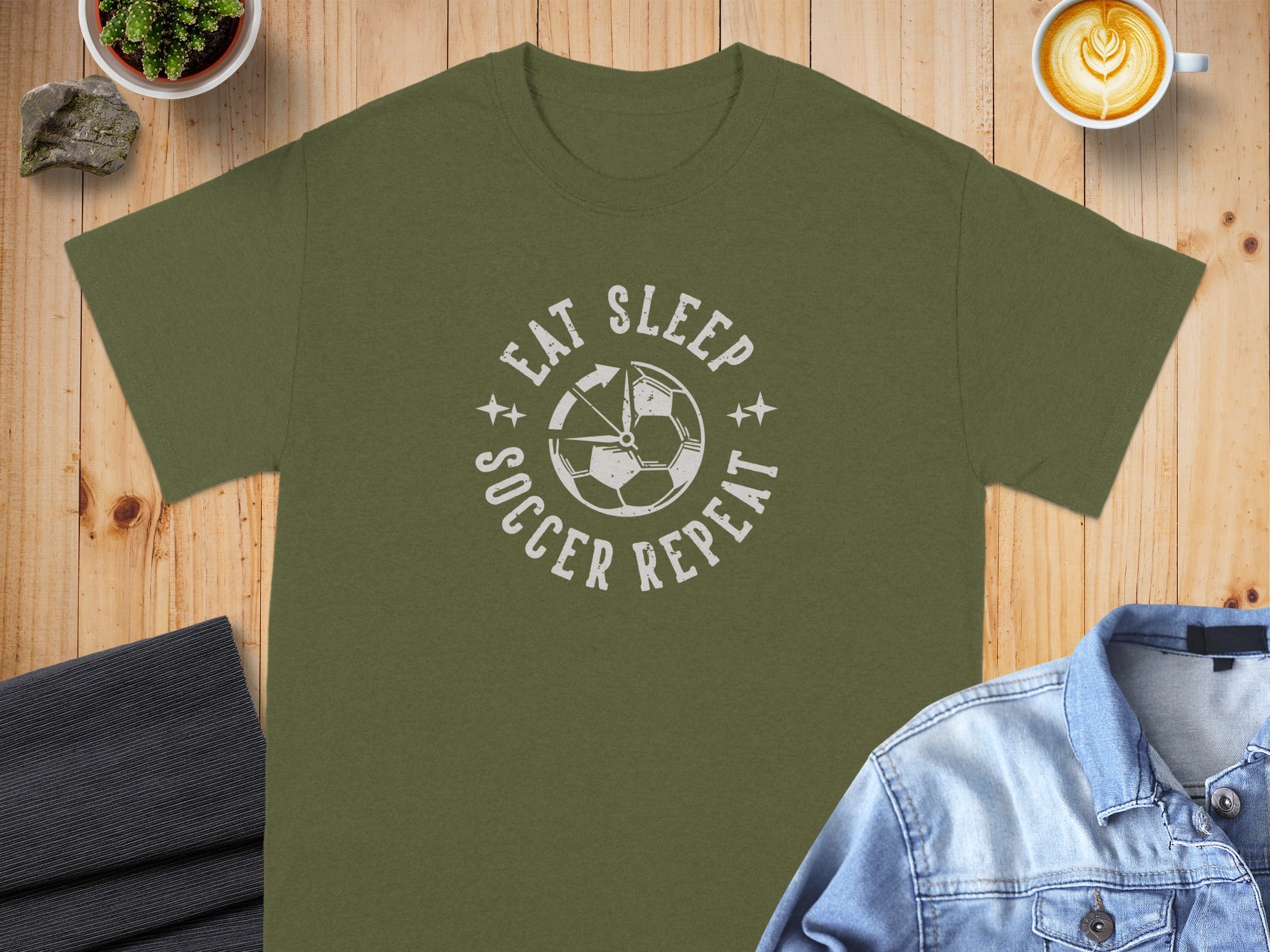 Olive t-shirt with "Eat Sleep Soccer Repeat" graphic and soccer ball design.