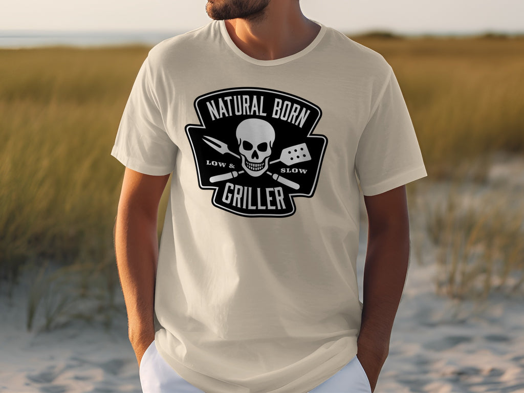 Light beige t-shirt with black graphic: Natural Born Griller, skull, fork, spatula, low & slow.