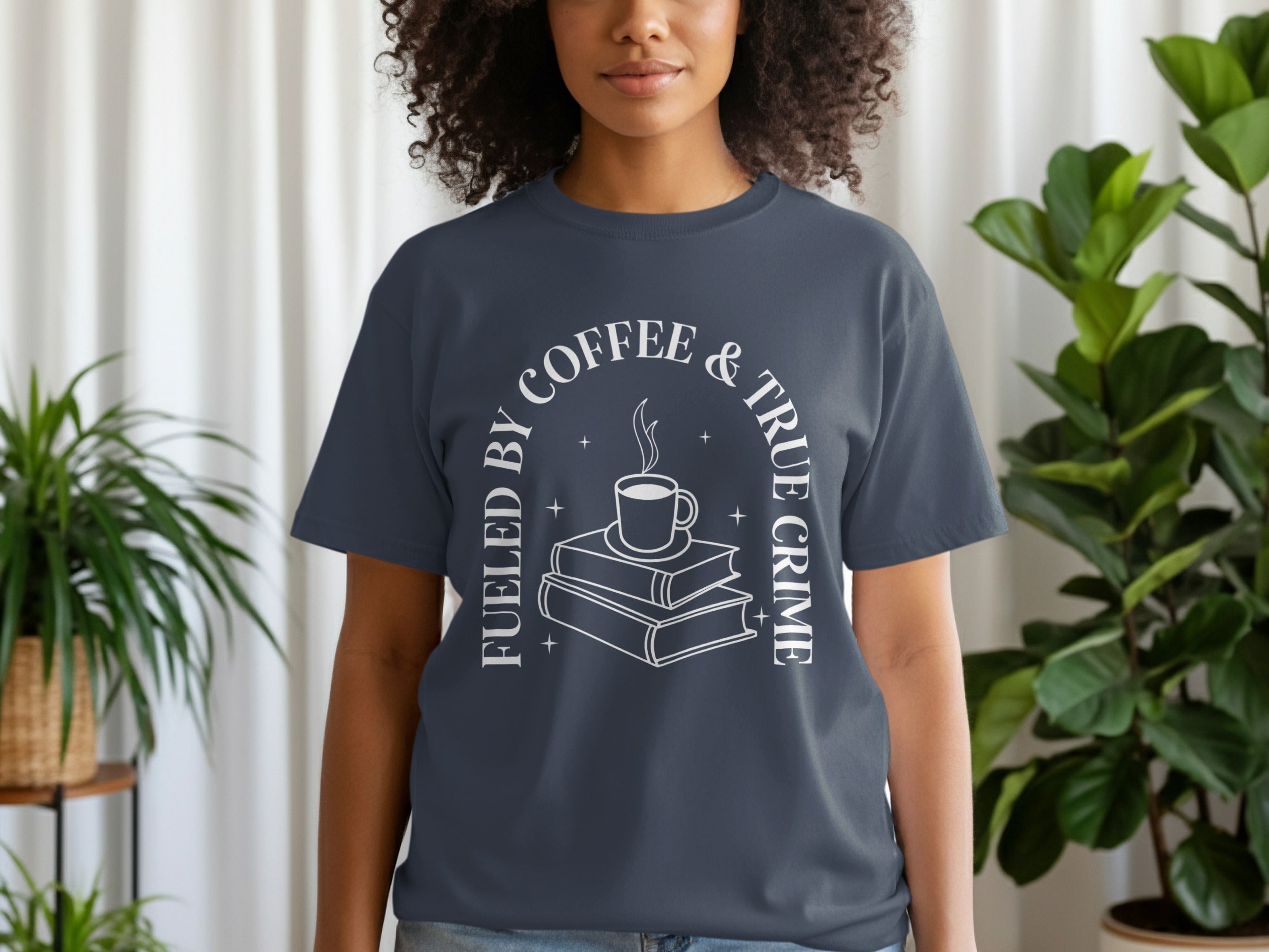 Dark grey t-shirt with white text: "Fueled by Coffee & True Crime" and image of books and coffee.