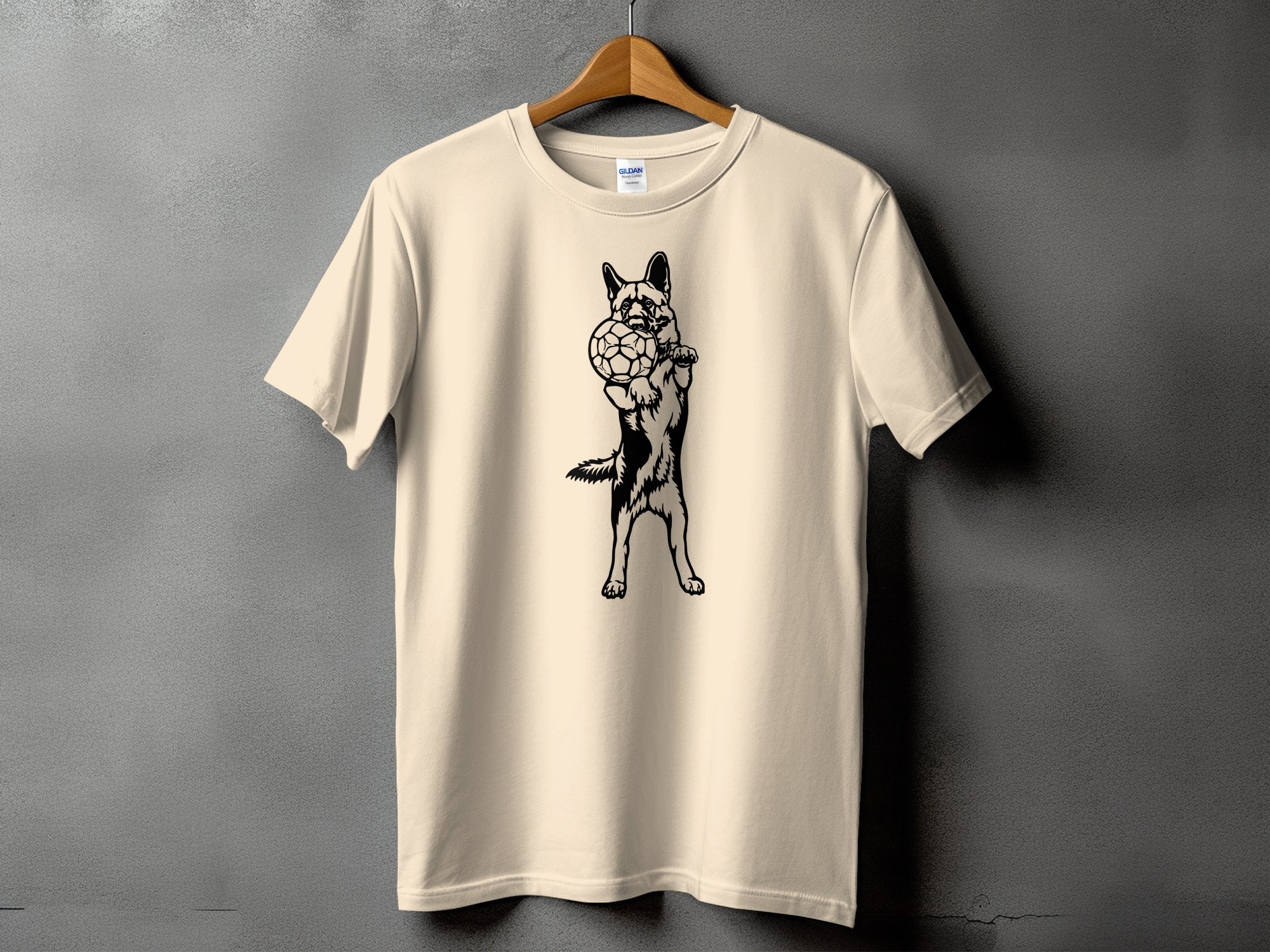 Beige t-shirt with black graphic of a German Shepherd holding a soccer ball.