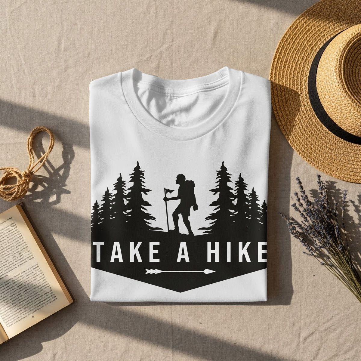 White t-shirt with "TAKE A HIKE" text and hiker silhouette among trees.