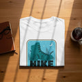 White t-shirt with teal hiking boot graphic and "Hike" text.