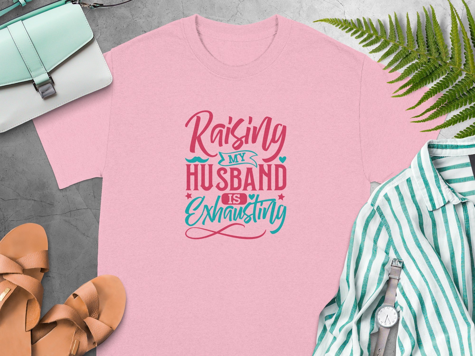 Pink t-shirt with "Raising my husband is exhausting" text.