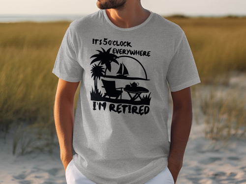 Grey t-shirt with black graphic: "It's 5 O'Clock Everywhere. I'm Retired."