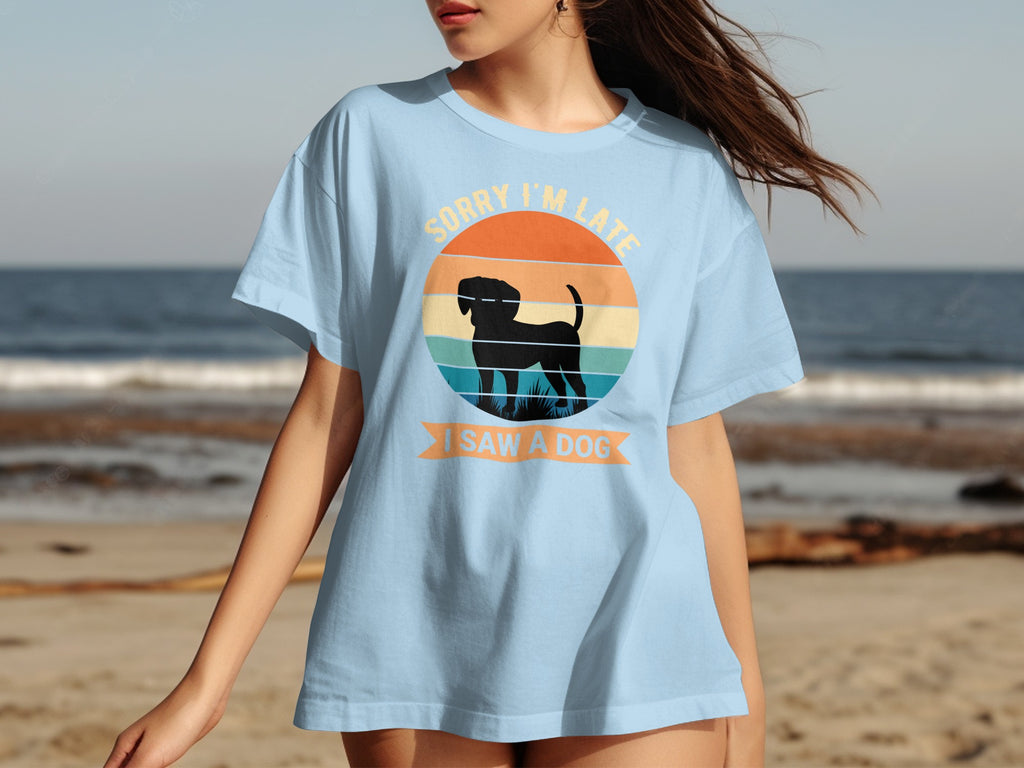 Light blue t-shirt with sunset graphic and silhouette of dog. Sorry I'm late I saw a dog.
