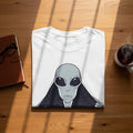 White t-shirt with a grey alien face graphic and starry background design.