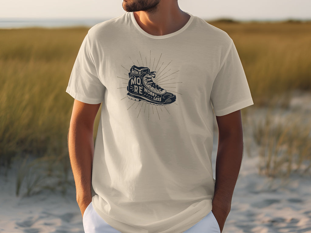 White t-shirt with dark graphic of a hiking boot and text "Hike More Worry Less".