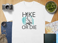 White t-shirt with "Hike Or Die" text and skeleton graphic.