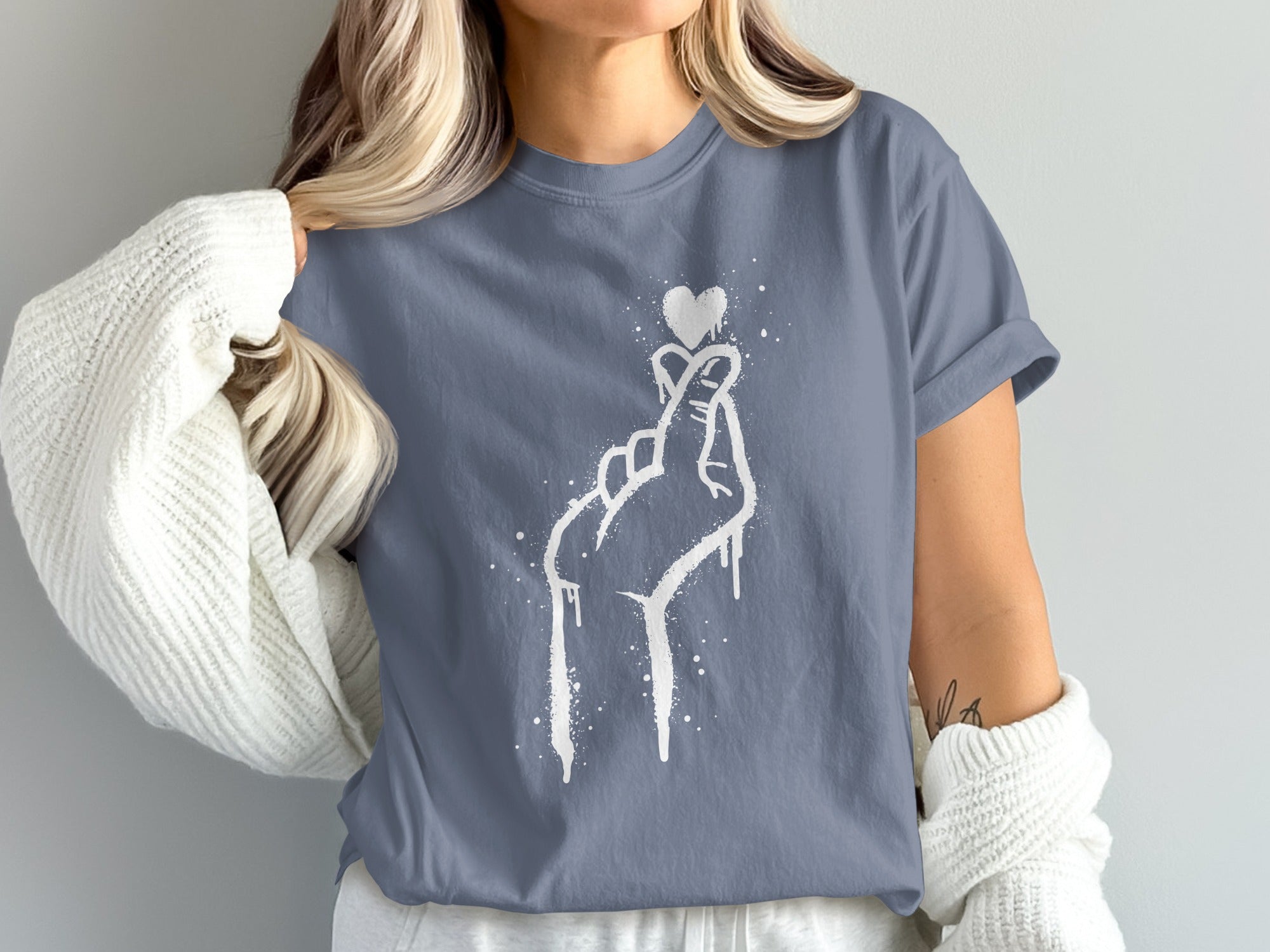 Gray t-shirt with white spray-painted hand making heart gesture and small heart.