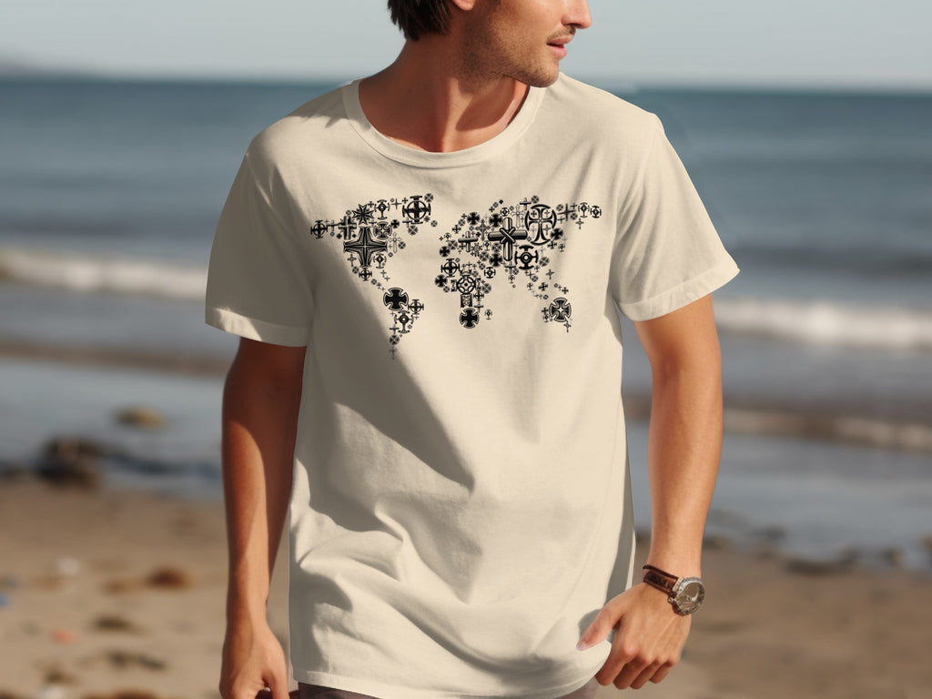 Cream t-shirt with black world map graphic made of various crosses on a beach background.