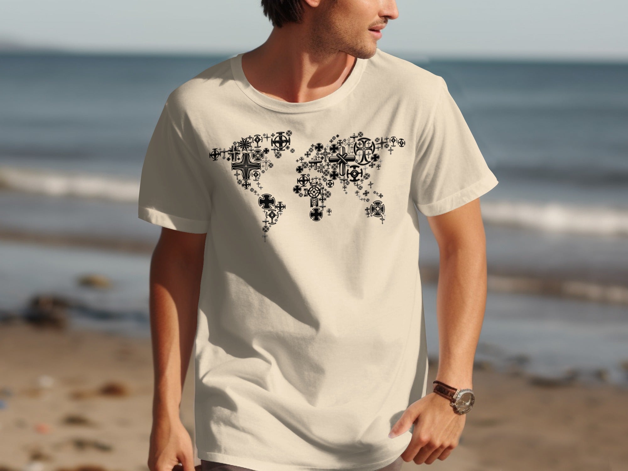 Cream t-shirt with black world map graphic made of various crosses on a beach background.