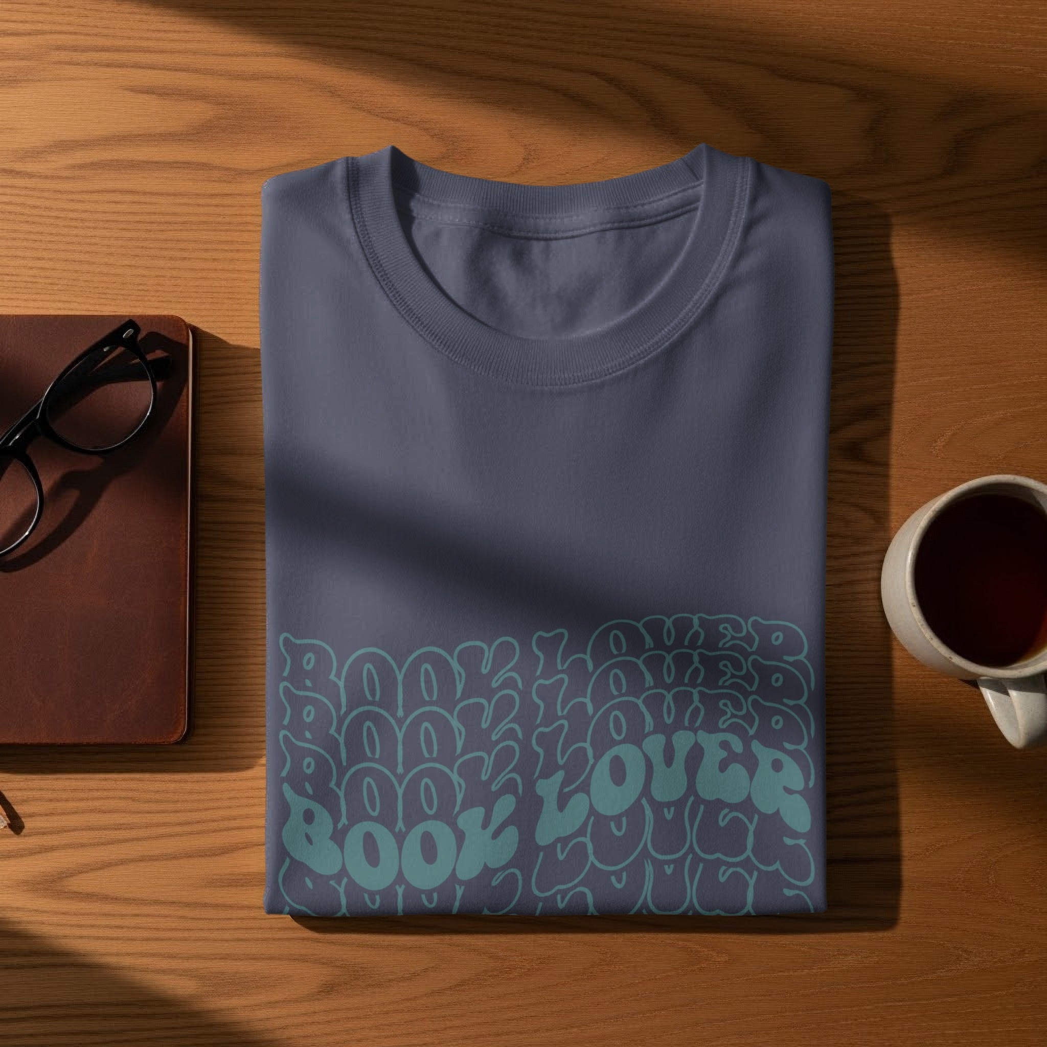 Dark blue t-shirt with "Book Lover" in a repeating, wavy teal font.
