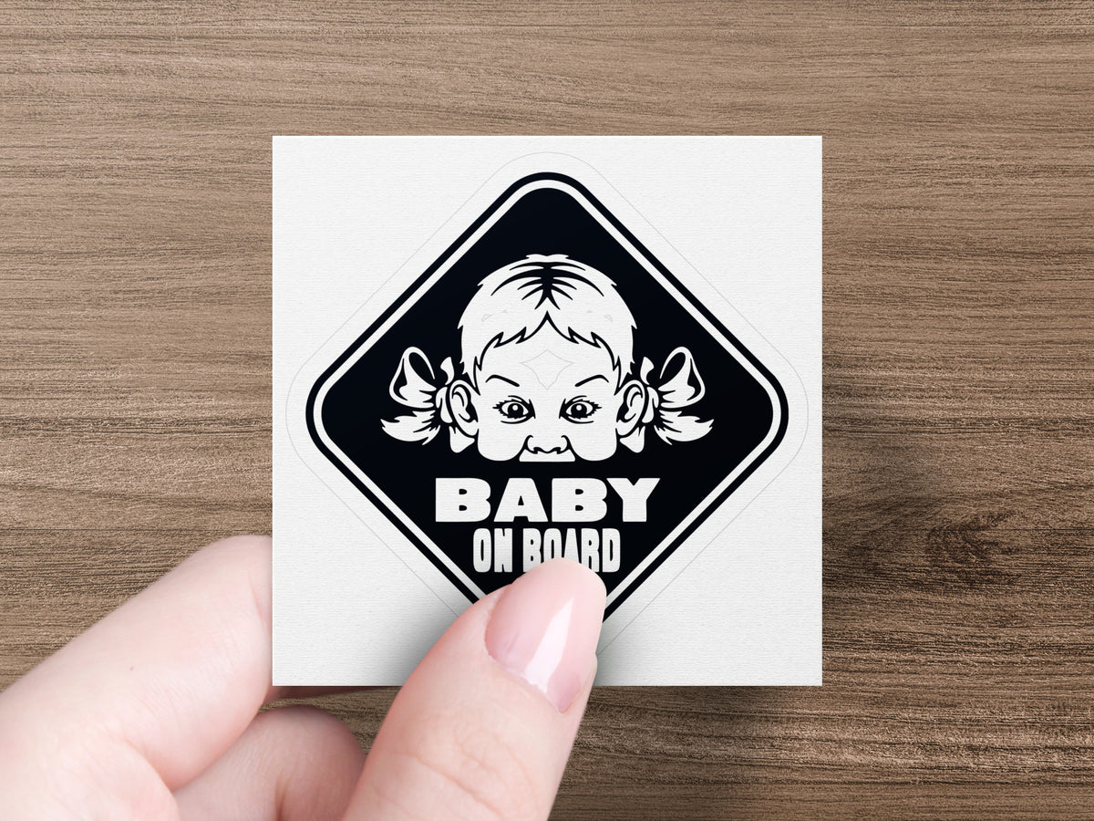 Baby on board decal with baby face and pigtails inside a diamond shape.