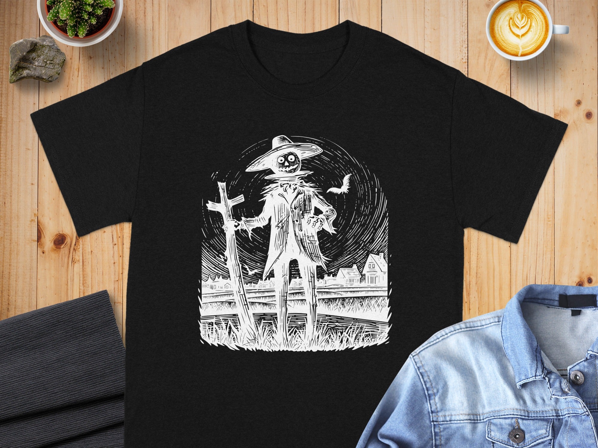 Black t-shirt with a white line art drawing of a scarecrow in a field.