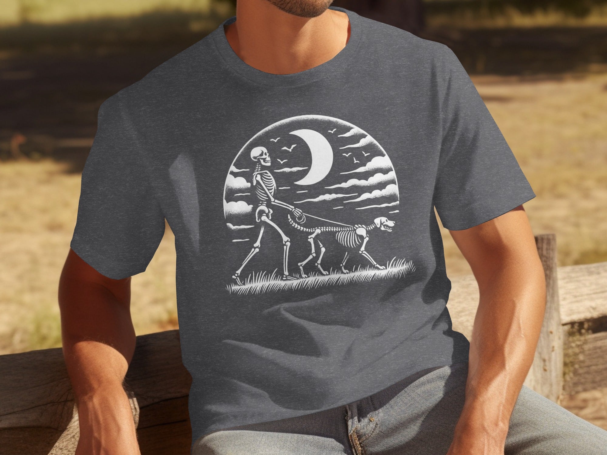 Skeleton walking a skeleton dog under a crescent moon and clouds design on a t-shirt.
