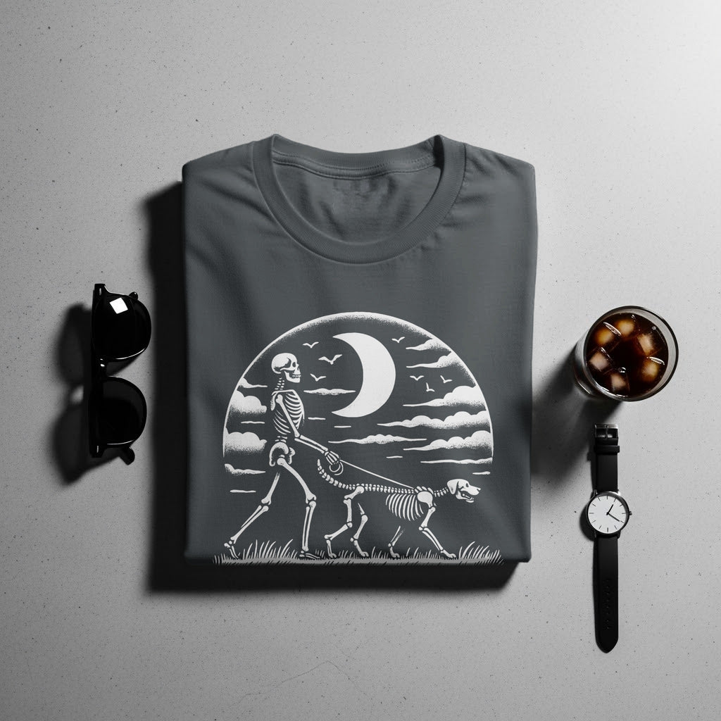 Dark grey t-shirt with a graphic of a skeleton walking a skeleton dog under a crescent moon.