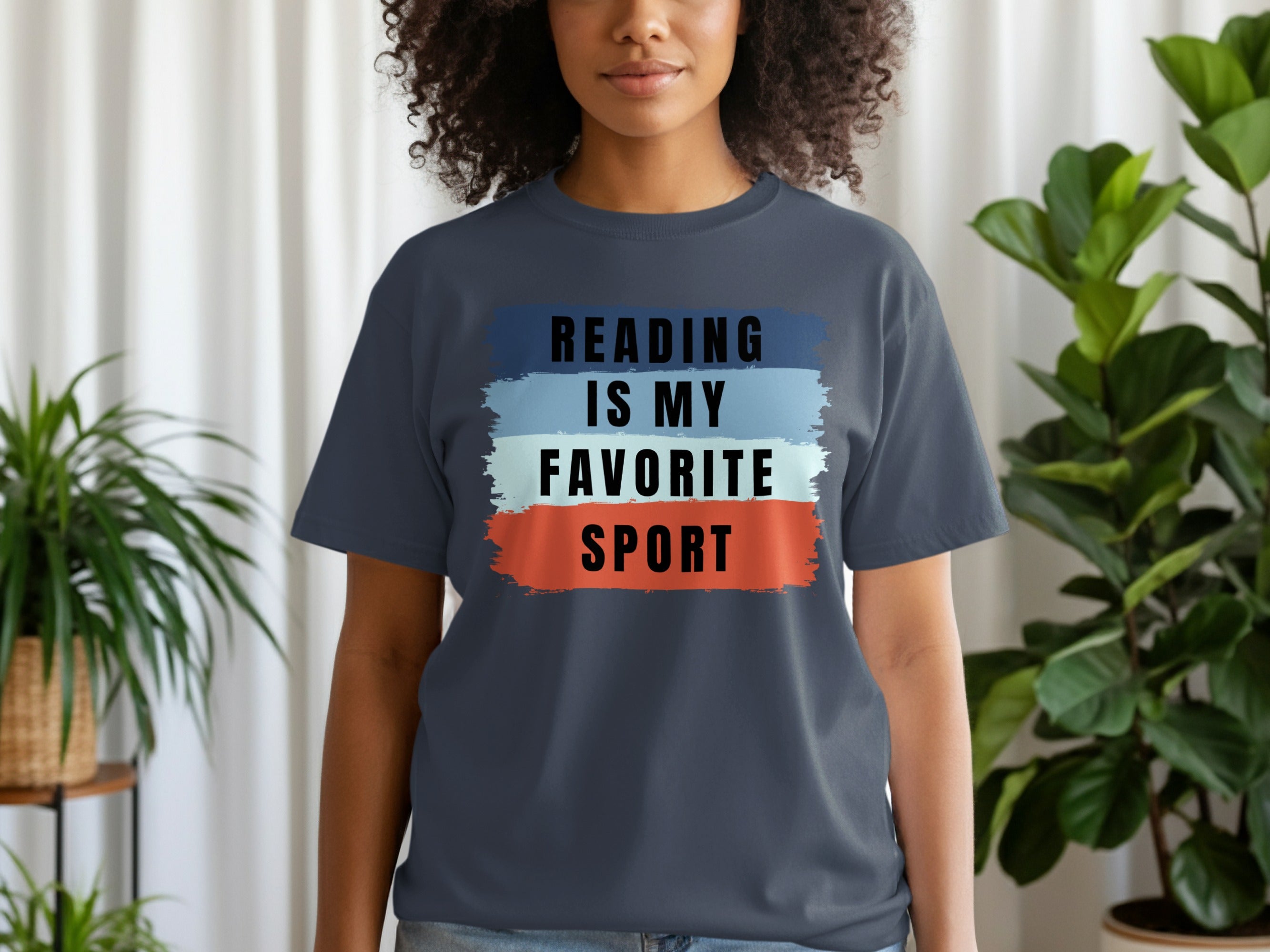 Dark grey t-shirt with "READING IS MY FAVORITE SPORT" text on colorful brush strokes.