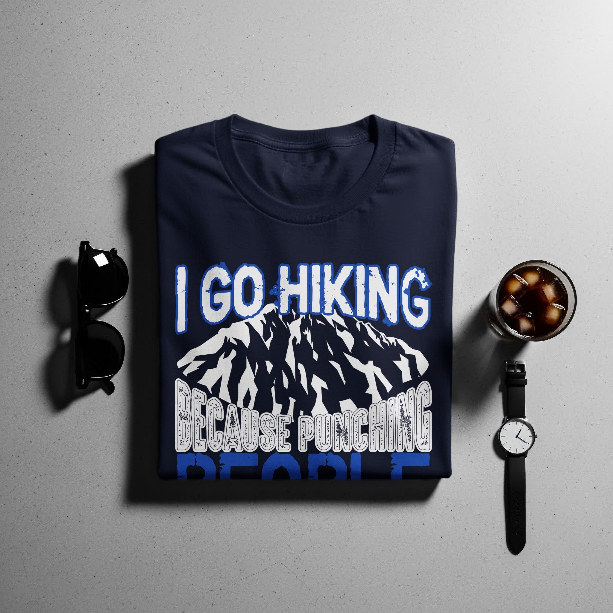 Navy t-shirt with "I GO HIKING BECAUSE PUNCHING PEOPLE" graphic and mountains.