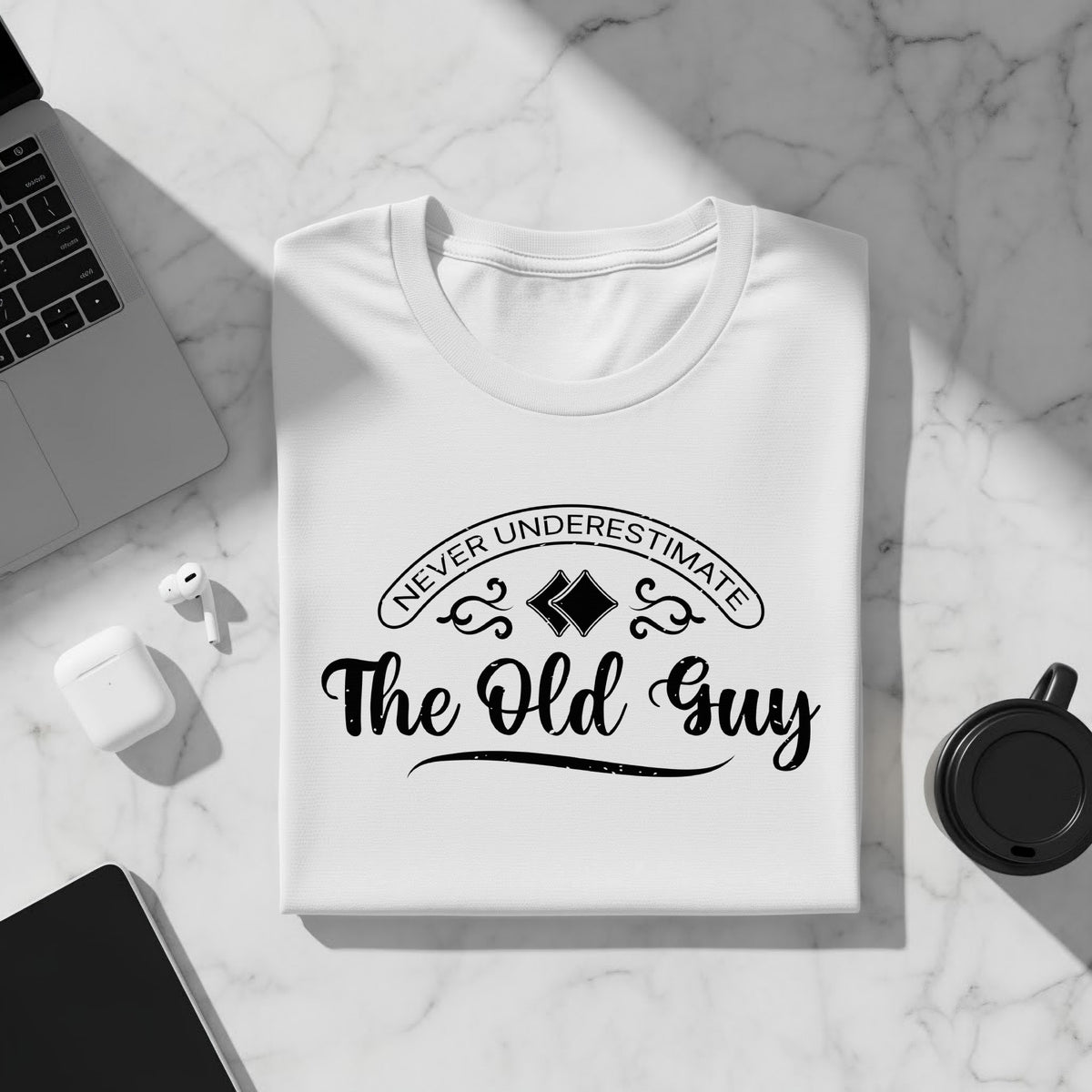 White t-shirt with "Never Underestimate The Old Guy" graphic