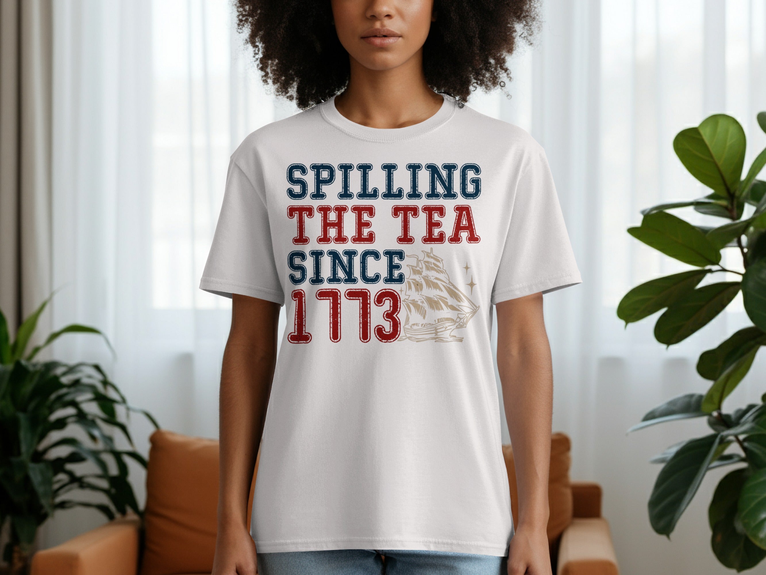White t-shirt with "Spilling The Tea Since 1773" text and ship graphic.