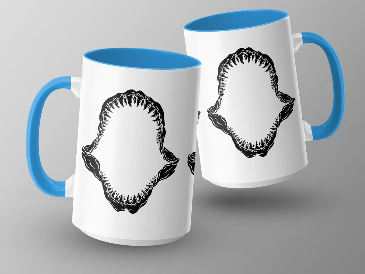 Two white mugs with blue handles and interiors, featuring black shark jaw designs.