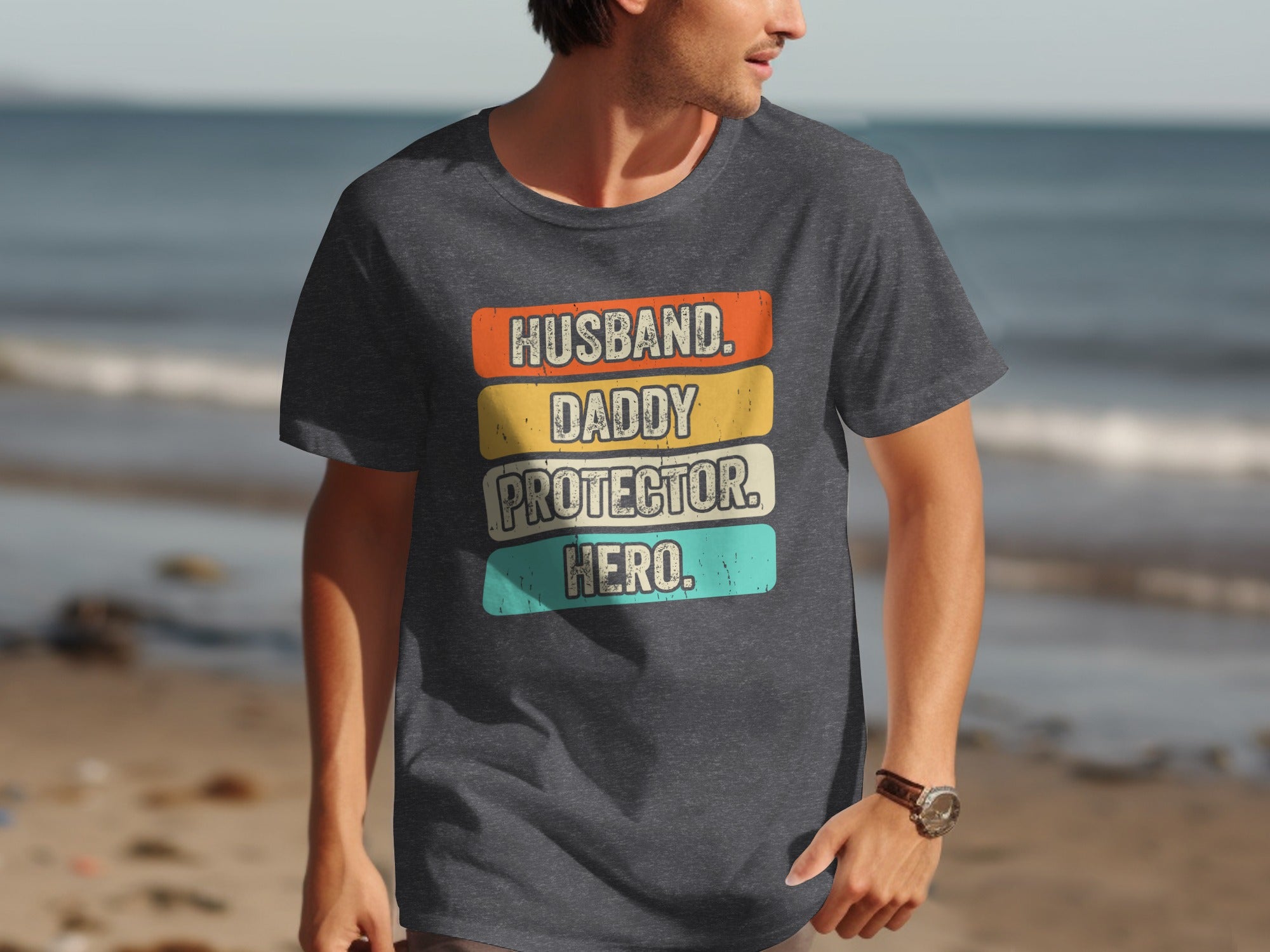 Dark gray t-shirt with text "Husband. Daddy. Protector. Hero." in distressed vintage style.
